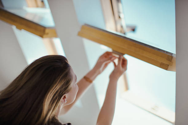 Young woman opening window. stock photo