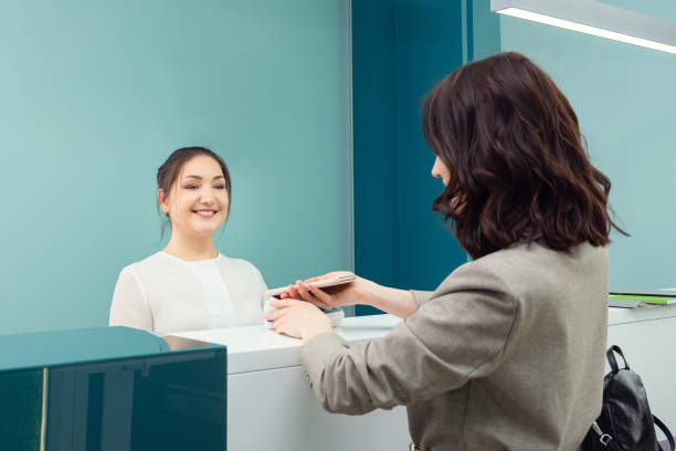 young woman pays for the service through the terminal stock photo