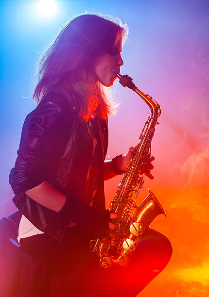 young-woman-playing-saxophone-at-the-nightclub-picture-id469567642
