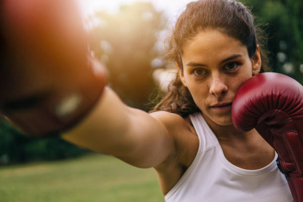 Young woman practicing boxe outdoors stock photo