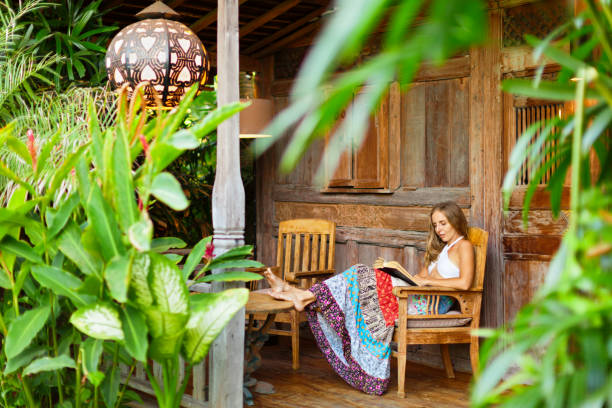Young woman read paper book on outside veranda stock photo