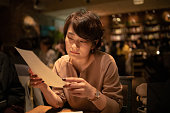 カフェでメニューを読む若い女性