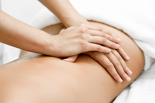 Joven mujer recibiendo un masaje de espalda en un centro de spa. photo