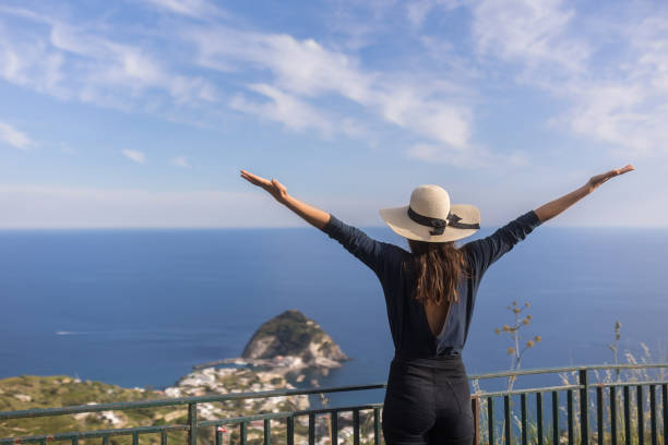 Young woman relaxes at coastal viewpoint stock photo