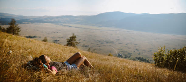Young woman relaxing during the hike in the countryside stock photo