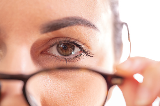 Close up of young woman removing eyeglasses