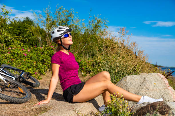 Young woman resting after riding bicycle at seaside stock photo