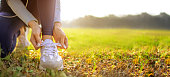 istock young woman runner tying her shoes preparing for a jog outside at morning 1298108434