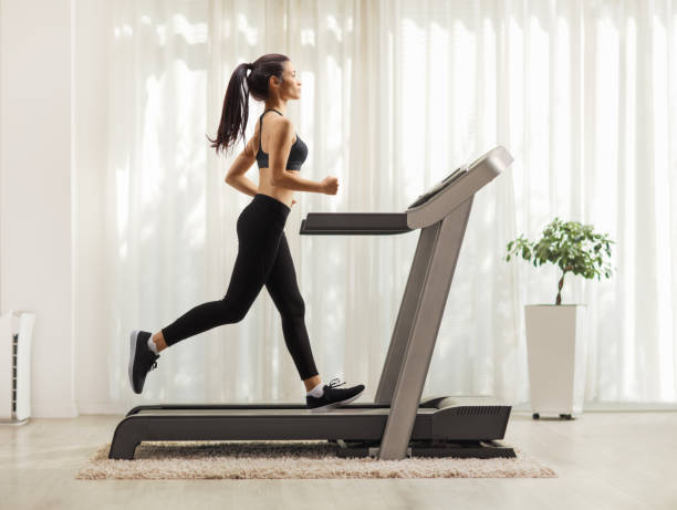 wanita muda berjalan di treadmill di dalam ruangan - treadmill potret stok, foto, & gambar bebas royalti