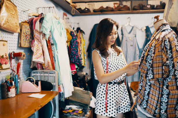 młoda kobieta robi coś na zakupy w sklepie z odzieżą vintage - small business saturday zdjęcia i obrazy z banku zdjęć