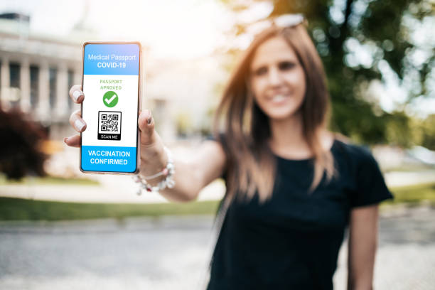 Young woman showing a digital vaccine certificate on her smartphone stock photo