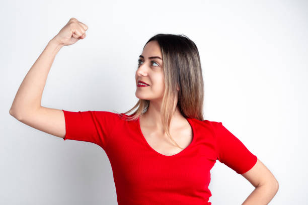 Young woman shows her strong arm. international women's day concept. stock photo