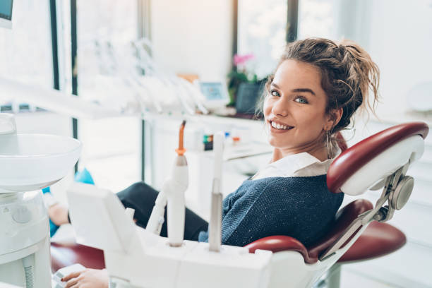 jovencita sentada en la silla de un dentista - sonrisa con dientes fotografías e imágenes de stock