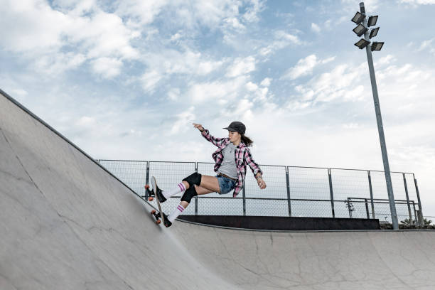 Young woman skating in skateboard park stock photo