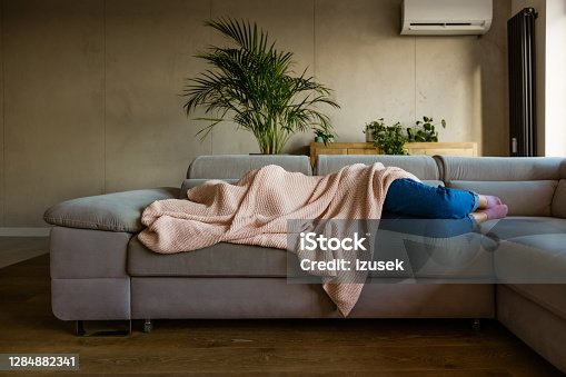 istock Young woman sleeping under blanket 1284882341
