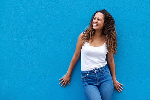 Young woman smiling against blue background
