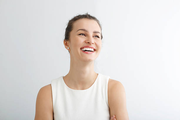 Young woman smiling against white background stock photo