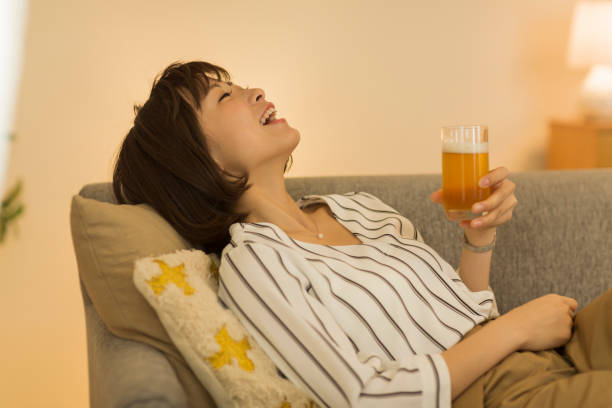 自宅で過ごす若い女性 - お酒 ストックフォトと画像