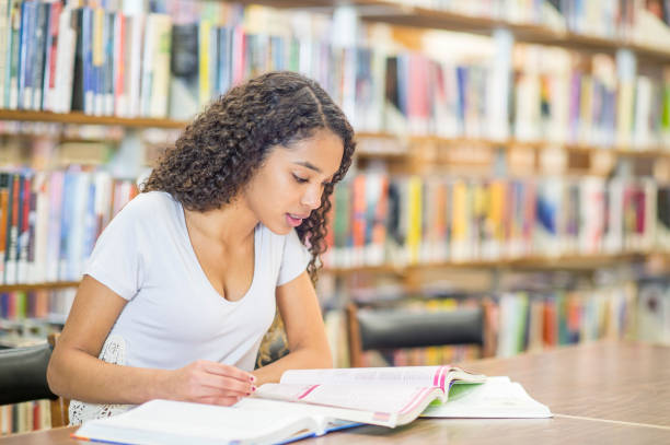 Young woman studying in a library stock photo