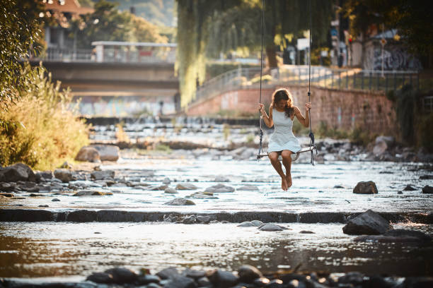 年輕女子在溪邊搖擺 - freiburg 個照片及圖片檔