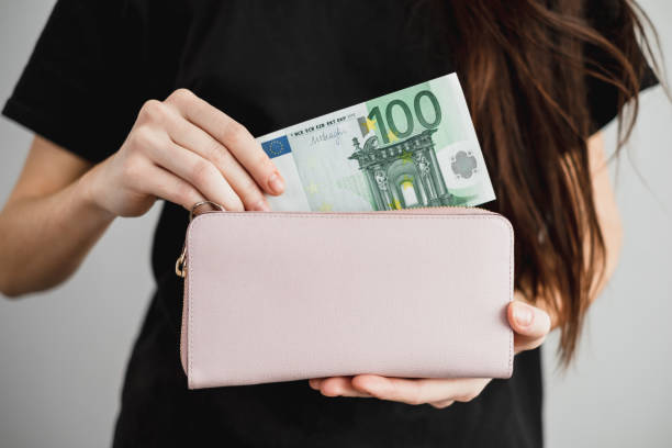 Young woman takes out money euro banknotes from a leather wallet. Close up Young woman takes out money euro banknotes from a leather wallet. Close up. High quality photo spending money stock pictures, royalty-free photos & images