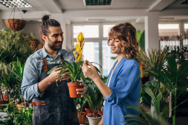 Young woman talking with male florist at the flower shop stock photo