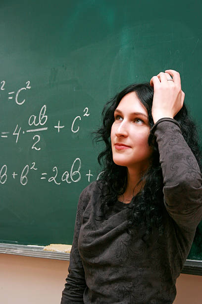 Young woman thinking near the blackboard stock photo