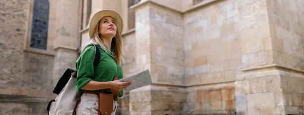 Young woman travel alone in old city centre. Wide photography. stock photo