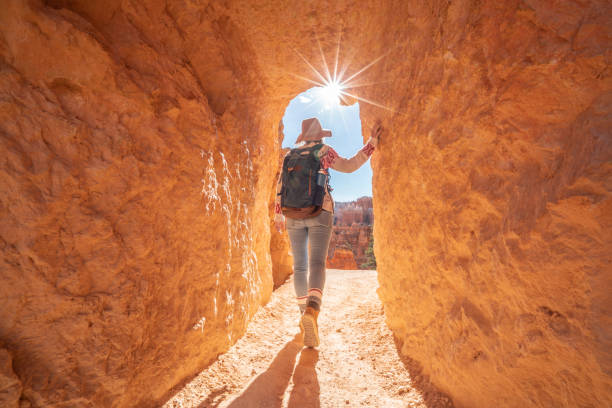 Young woman travels Bryce Canyon national park in Utah, United States, people travel explore nature. Girl hiking in red rock formations stock photo