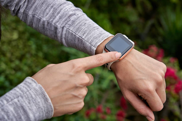 Young woman tries out a generic but modern touch screen smart-watch on his wrist. stock photo