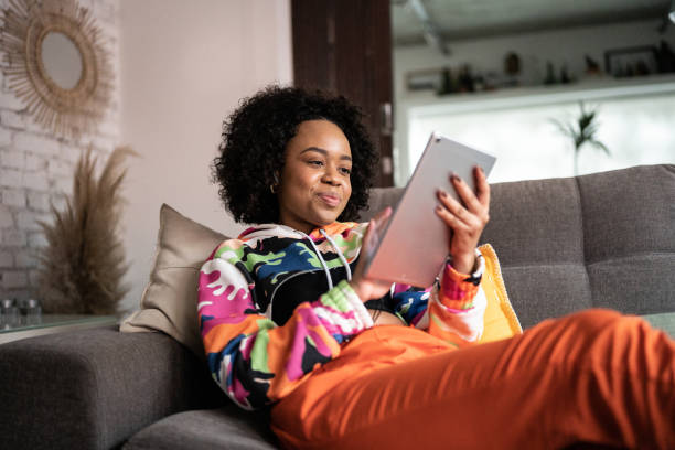 Young woman using a digital tablet at home stock photo