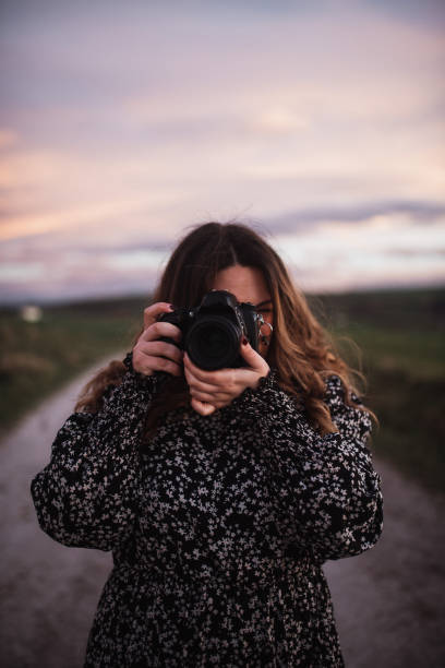 Young woman using a DSLR camera stock photo