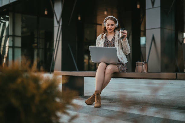 Young woman using a laptop during a coffee break stock photo