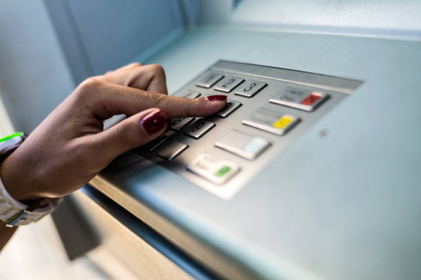 Young Woman using ATM machine. stock photo