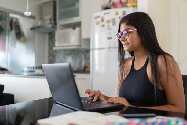 Young woman using laptop at home Home lifestyle south american woman stock pictures, royalty-free photos & images