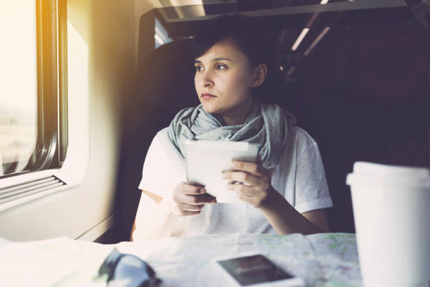jeune femme utilisant une tablette pc, un appareil mobile intelligent, voyageant - smartphone car photos et images de collection
