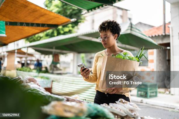 Young woman using the mobile phone at a street market