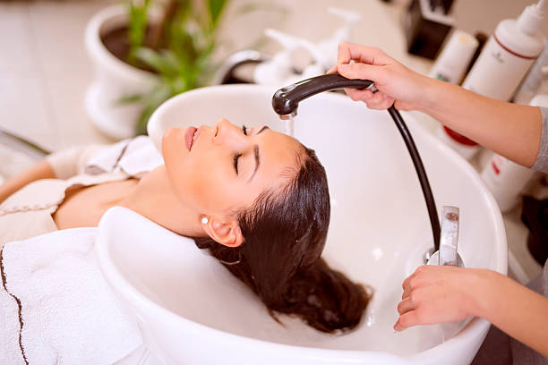 Young woman washing hair in salon stock photo