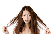 分裂に悩まされる若い女性は終わる。損傷した髪。美容とヘアケアのコンセプト。
