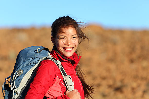 Young woman with a backpack smiling at camera Healthy lifestyle xwoman hiker smiling happy outside on hiking trip. Beautiful natural candid smile on mixed race Caucasian / Asian female hiker outdoors in nature. 20 29 years stock pictures, royalty-free photos & images