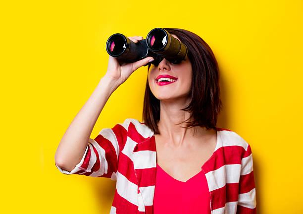 young woman with binoculars stock photo