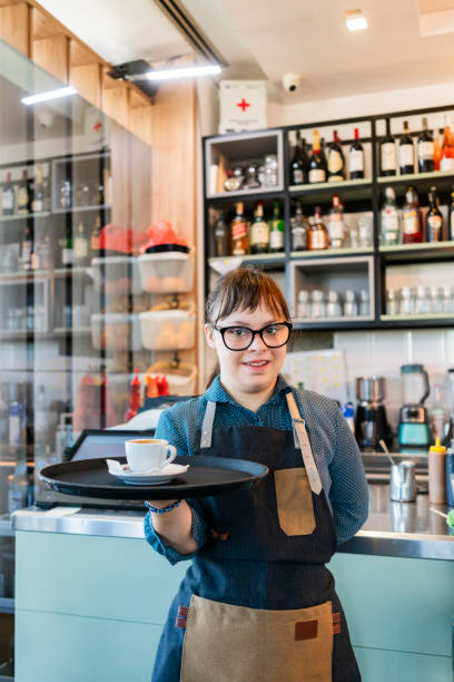Young woman with Down Syndrome working at cafe stock photo