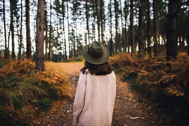 jeune femme avec chapeau à la forêt - marcher foret photos et images de collection