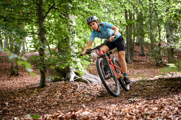 Young woman with mountain bike on Italian mountains: Downhill in the forest stock photo
