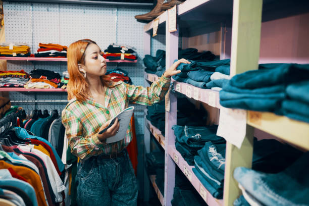 Young woman working in a vintage clothing store stock photo