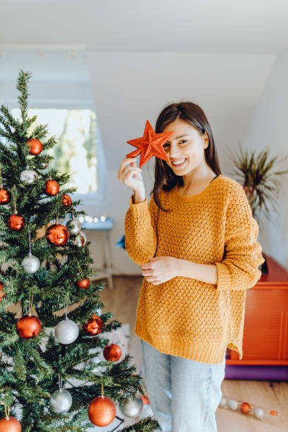 young women decorating her home for christmas stock photo