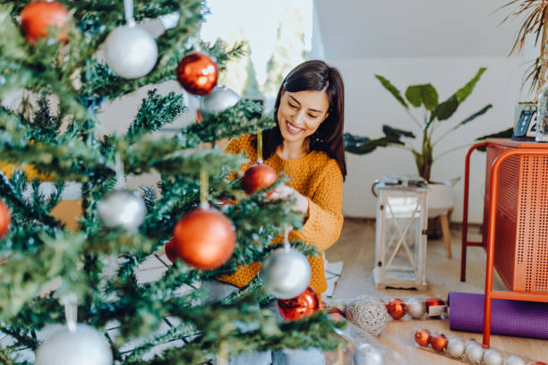 young women decorating her home for christmas stock photo