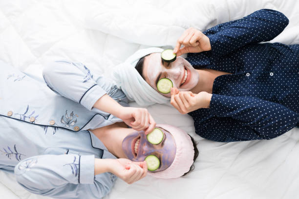 młode kobiety odpoczywające w sypialni podczas złuszczania twarzy - peeling ogórki zdjęcia i obrazy z banku zdjęć