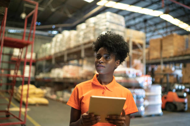 Young worker using digital tablet at warehouse for industrial observation 