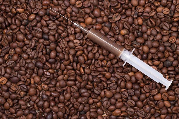 Your daily shot of coffee with syringe on coffeebeans stock photo
